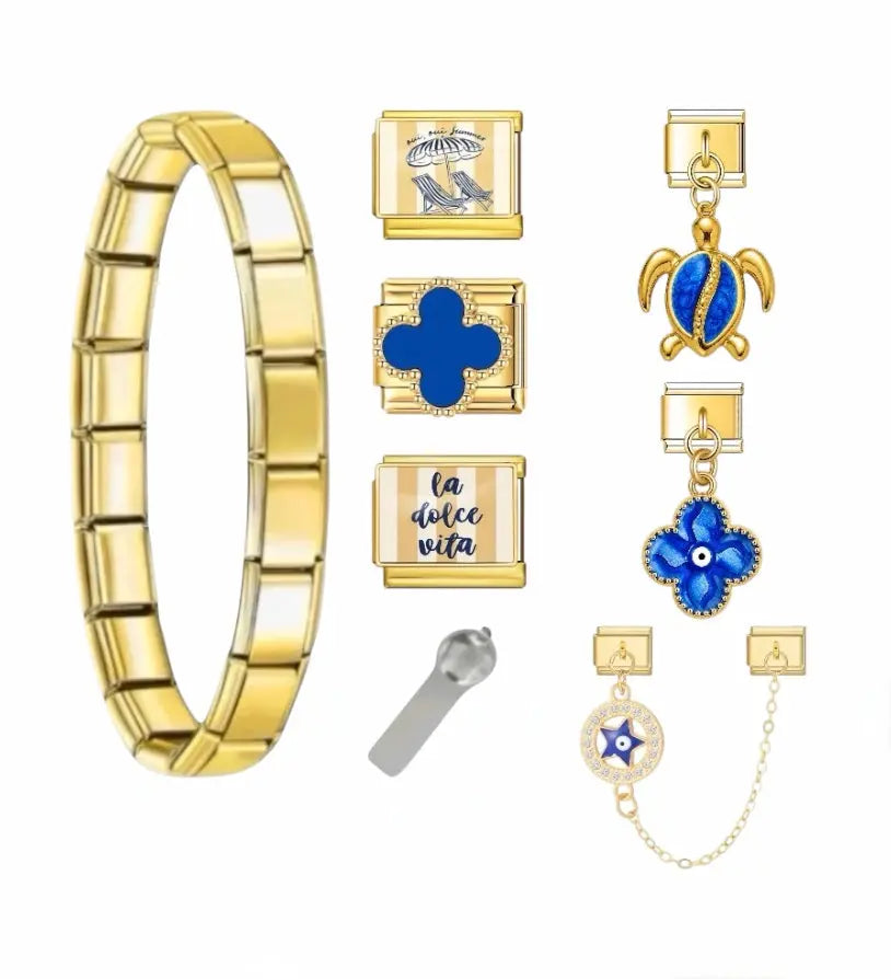Bracelet charm Dolce Vita en acier inoxydable doré avec charms bleus : trèfle, tortue, œil porte-bonheur et inscription la dolce vita — bracelet charm italien