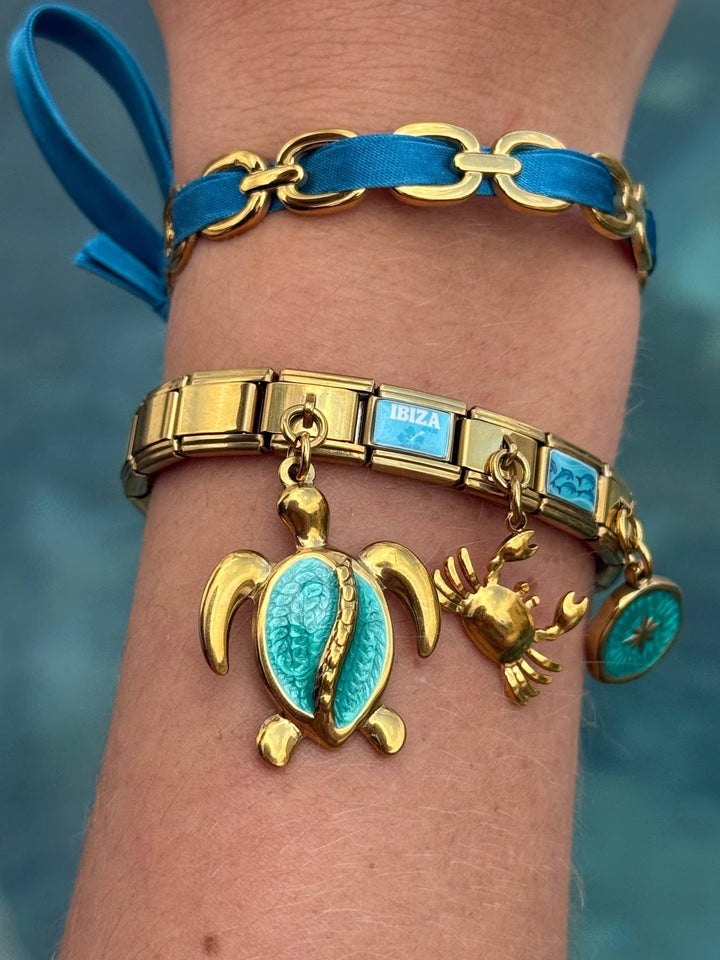 Bracelet Côte Turquoise porté au poignet, charms tortue et étoile turquoise, acier inoxydable
