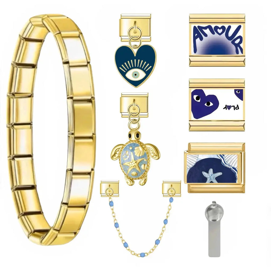 Bracelet charm italien Blue Amore en acier inoxydable doré avec charms bleu marine : coeur mauvais oeil, tortue émail bleu, étoile de mer et charm Amour
