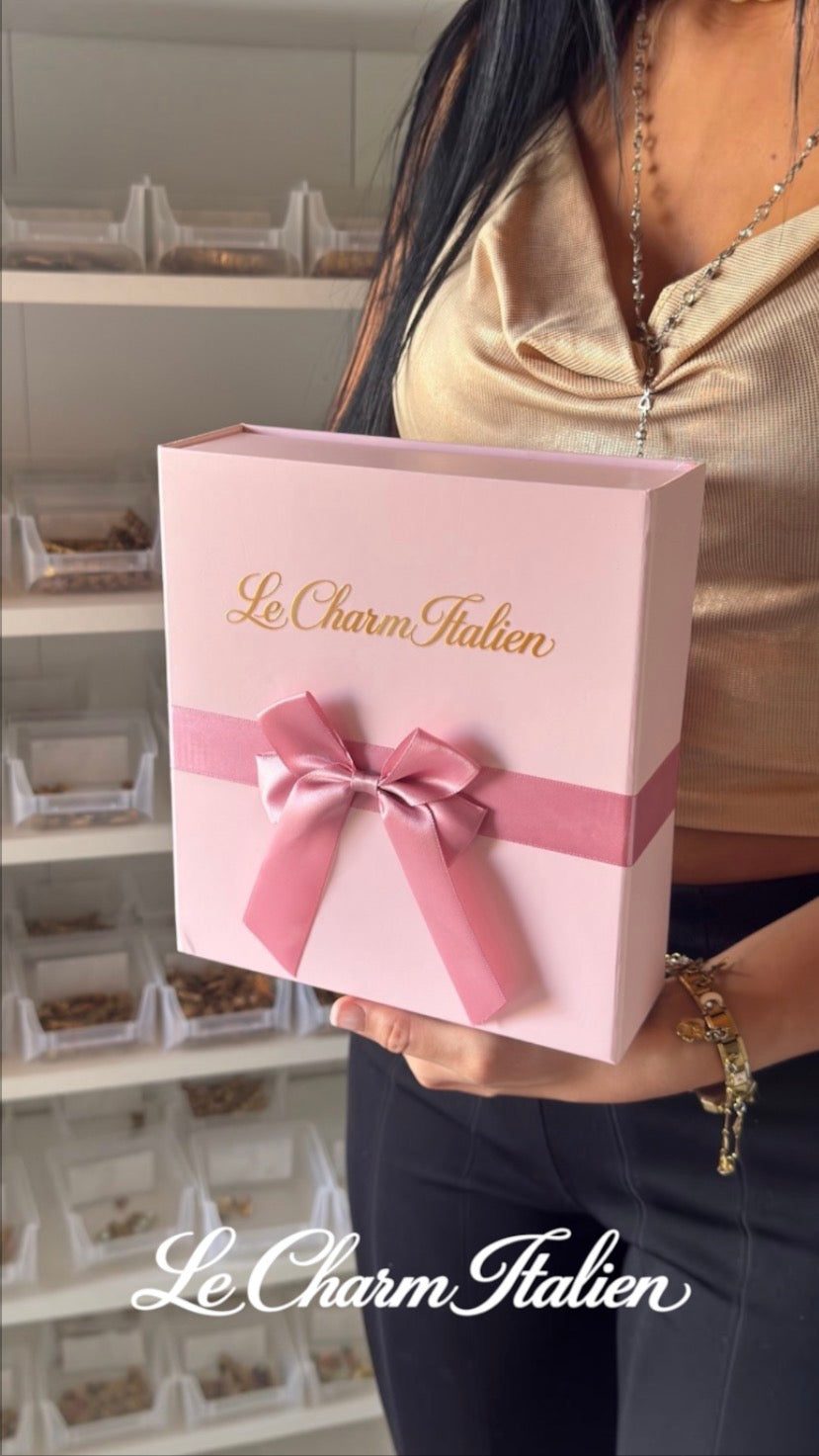 Calendrier de l'avent 2026 Le Charm Italien : coffret rose noué d'un ruban satiné, logo doré, tenu en main