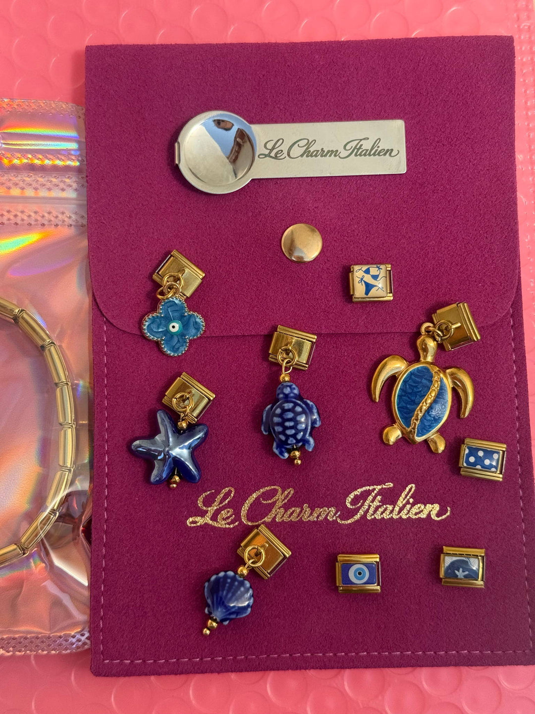 Pochette à bijoux fuchsia Le Charm Italien avec des charms italiens bleus : tortue, coquillage et étoile de mer